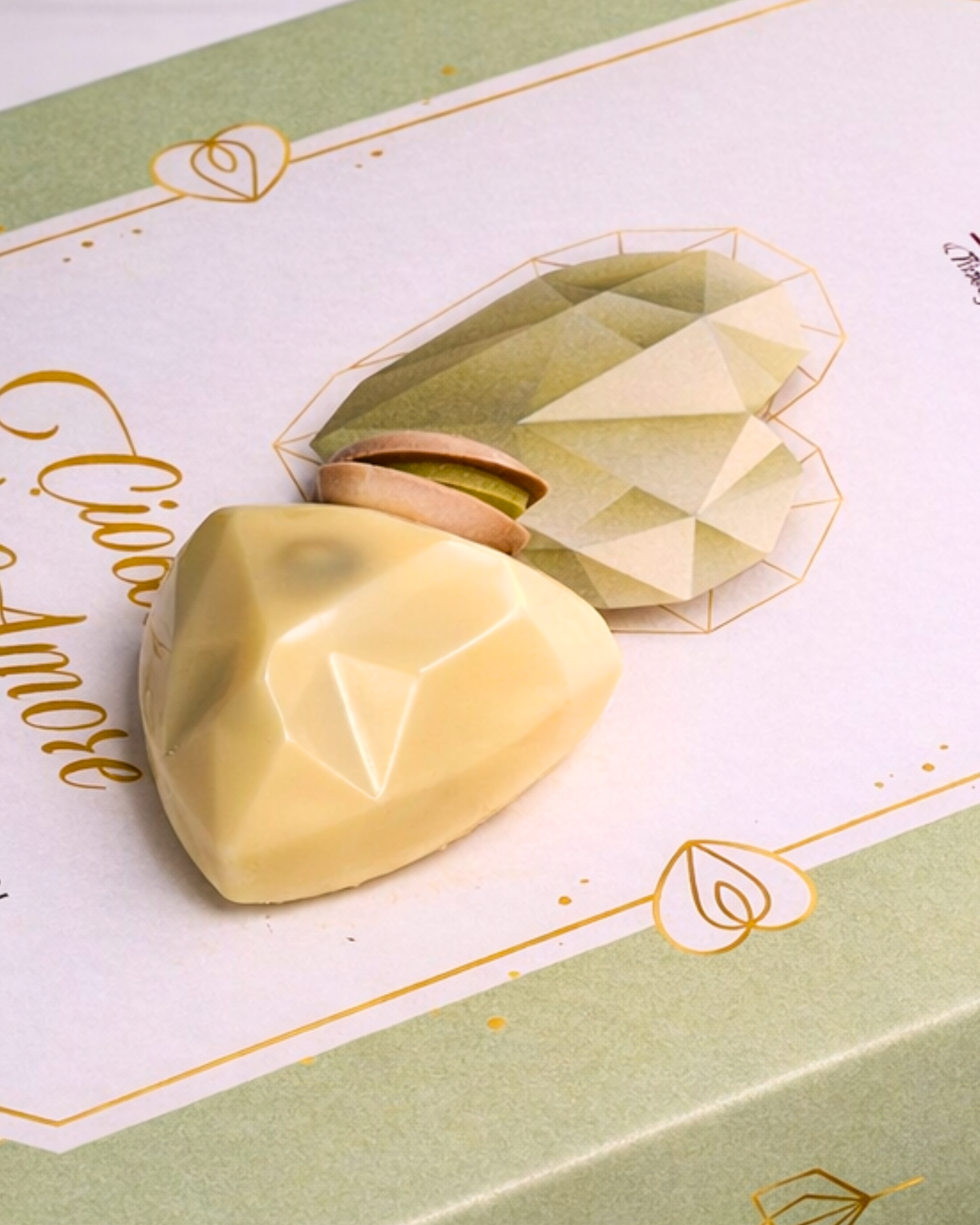 White chocolate and pistachio confections in an 80g box by Medri Tiramisu Cafe, showcasing glossy, handcrafted chocolates.