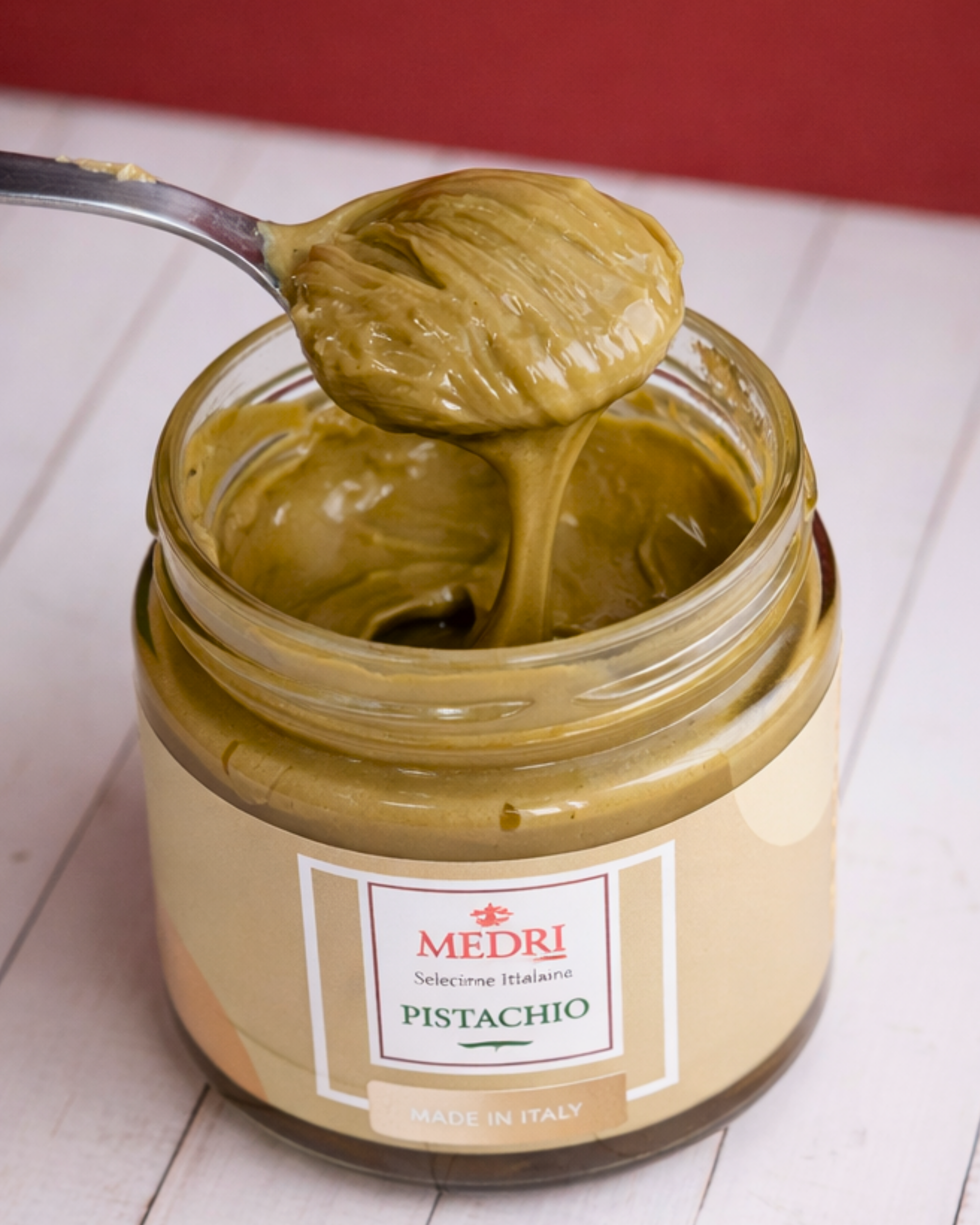 Creamy pistachio spread with 25% pistachios from Medri Tiramisu Cafe, shown in a jar with a smooth texture and green hue.