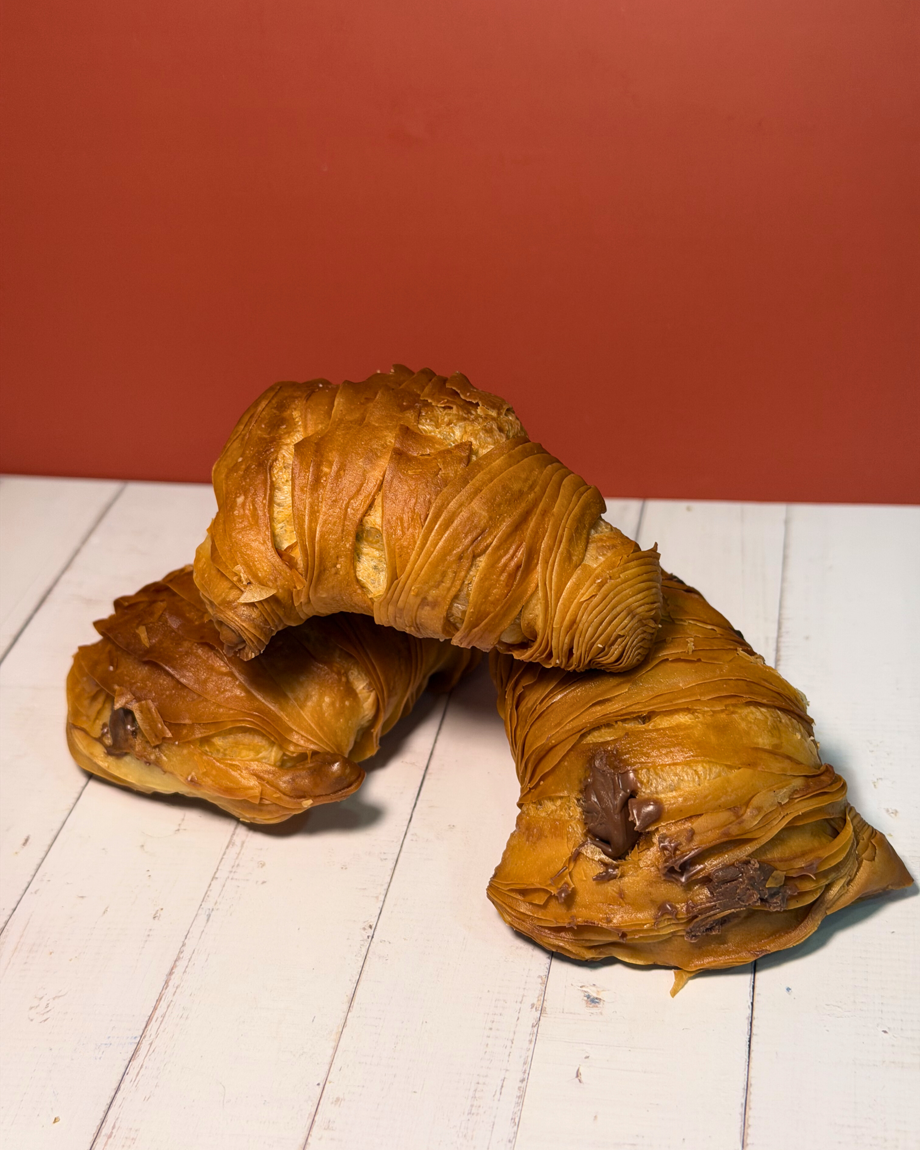 Medri Sfogliatella de Chocolate, golden flaky pastry filled with rich chocolate, topped with powdered sugar and chocolate drizzle.