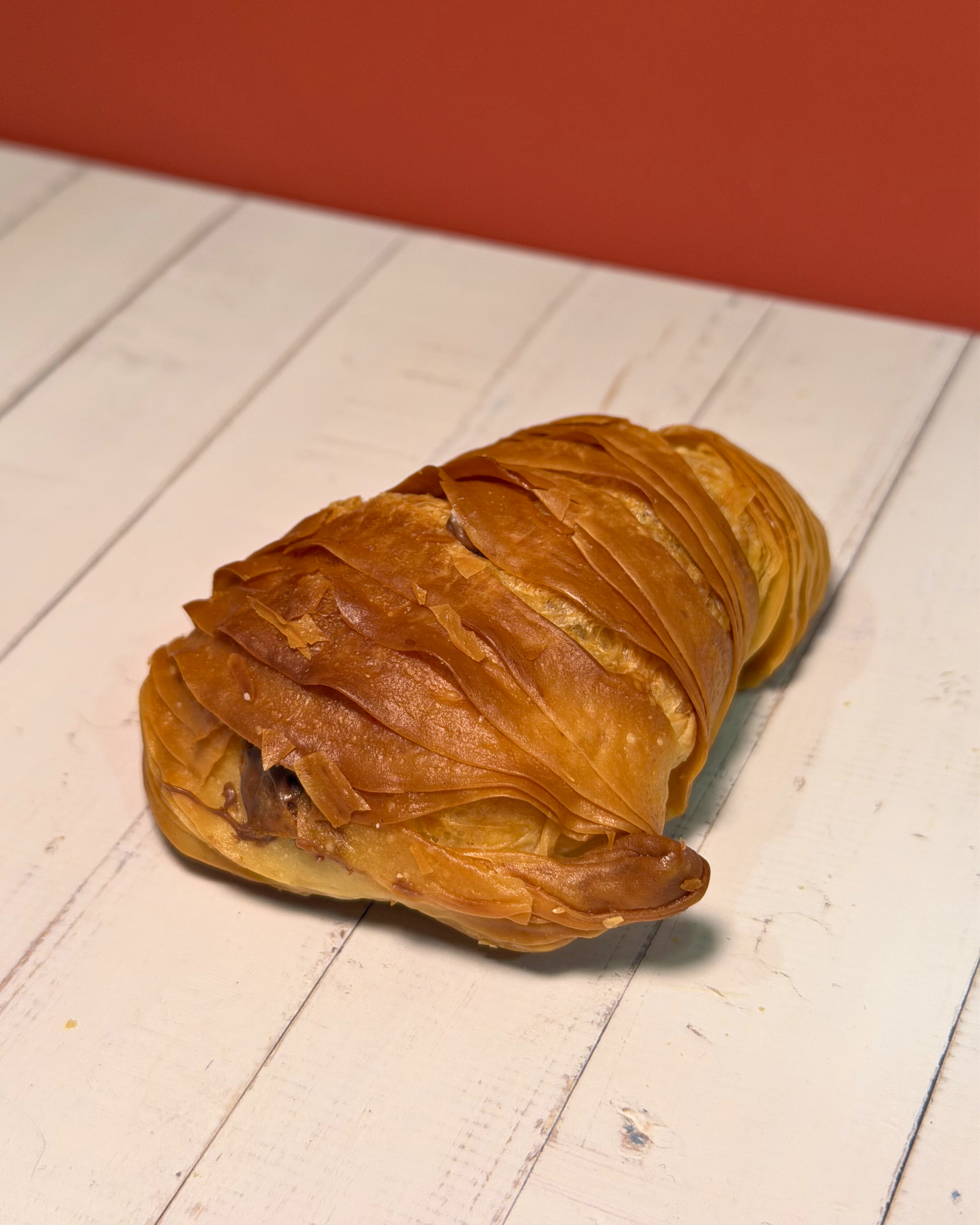 Chocolate sfogliatella pastry by Medri with flaky layers and rich chocolate filling, displayed on a white plate.