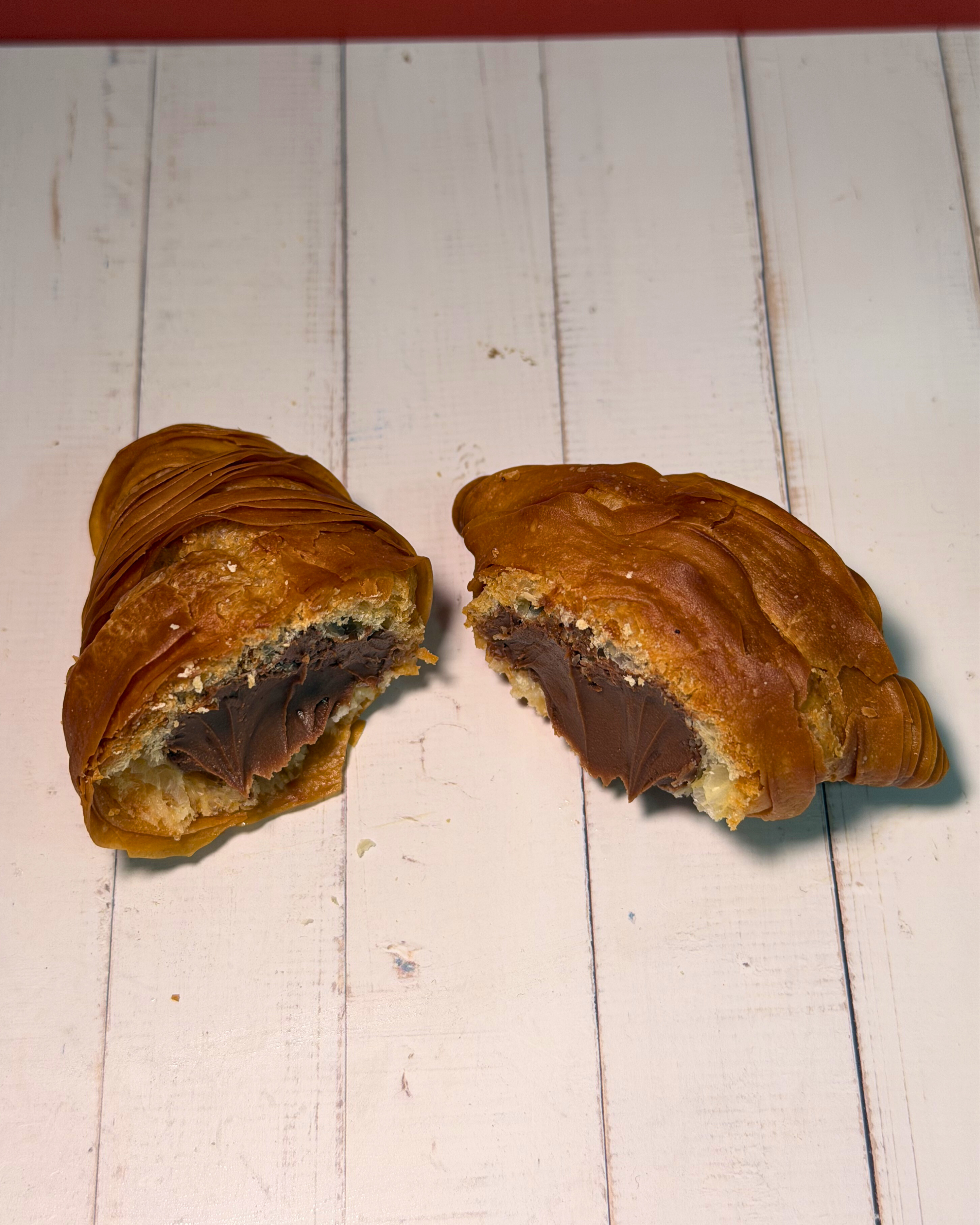 Medri Sfogliatella de Chocolate with flaky golden pastry and rich chocolate filling, topped with powdered sugar.