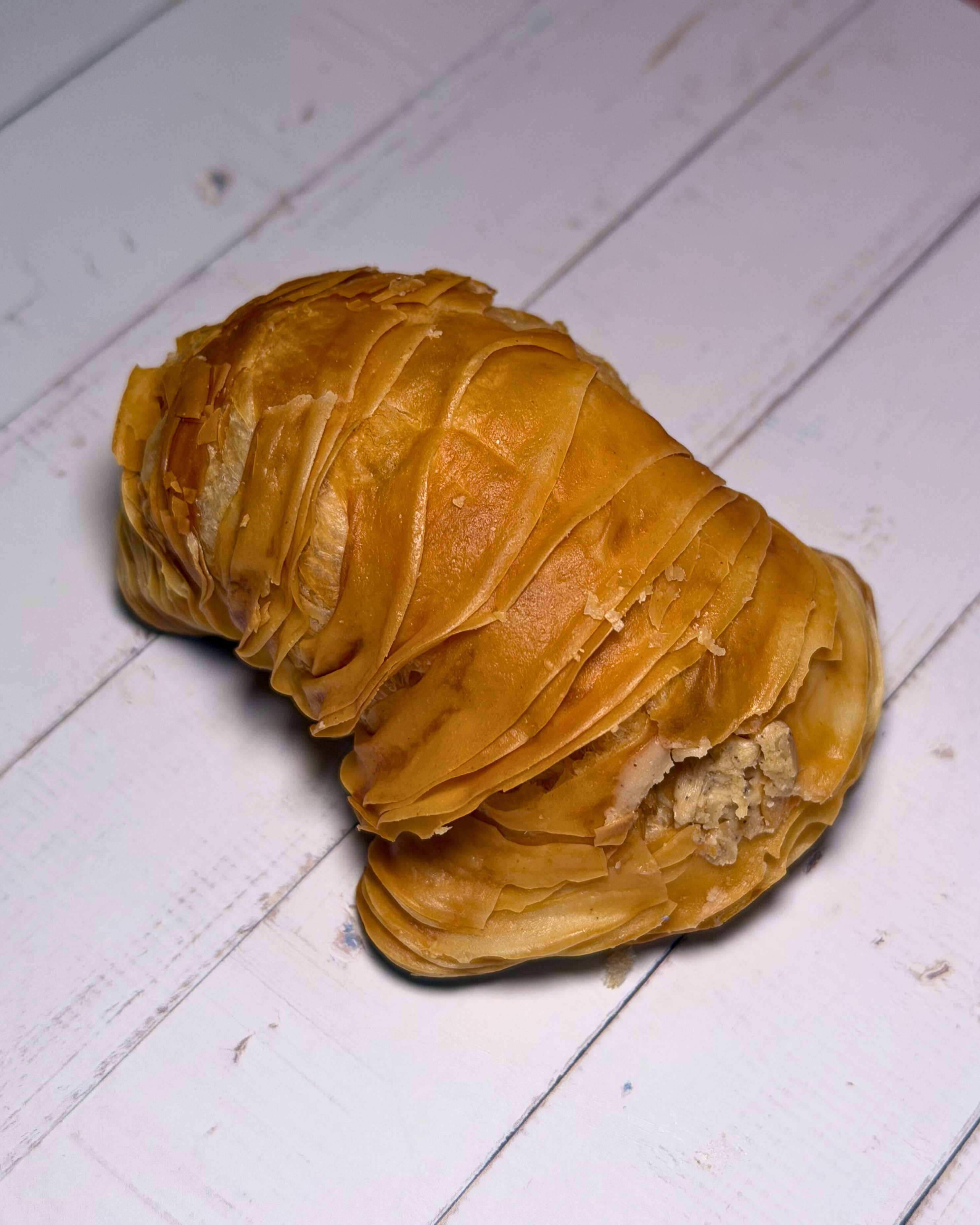 Medri Sfogliatella de Tiramisú pastry with layered, flaky crust and creamy tiramisú filling on a white plate.
