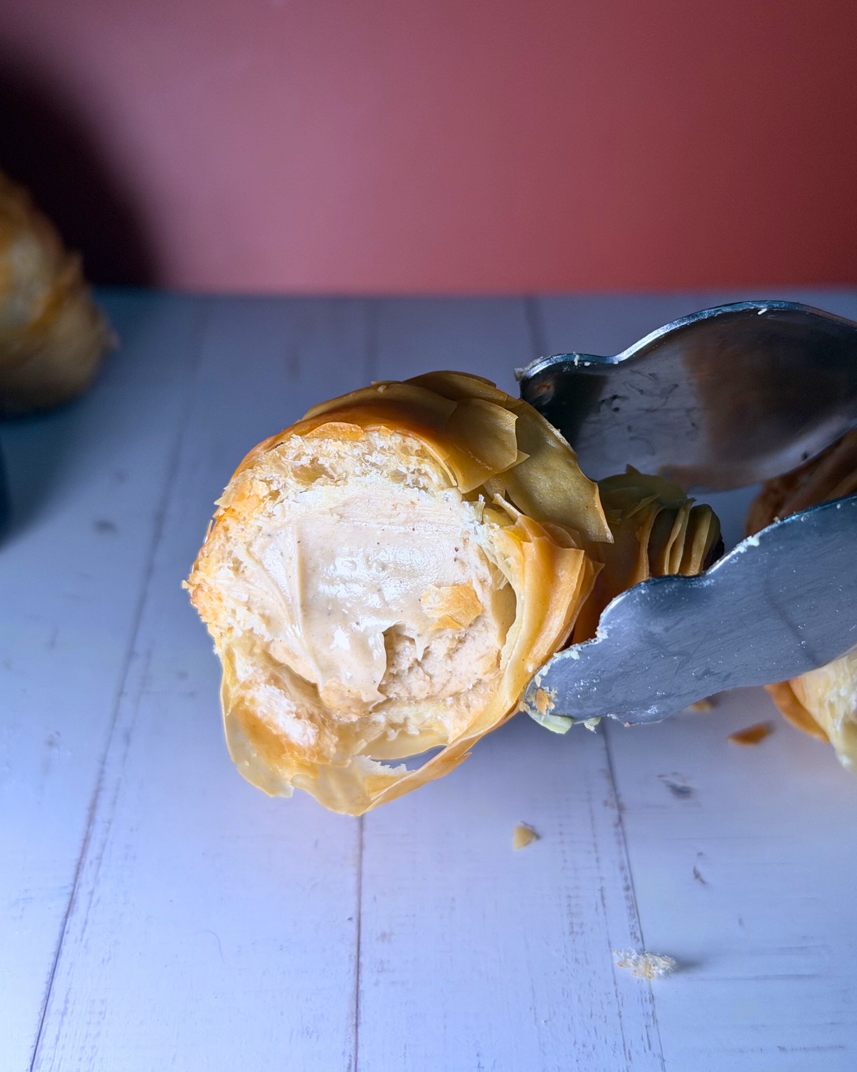 Medri Sfogliatella de Tiramisú pastry with layered, flaky crust and creamy tiramisú filling, presented on a white plate.