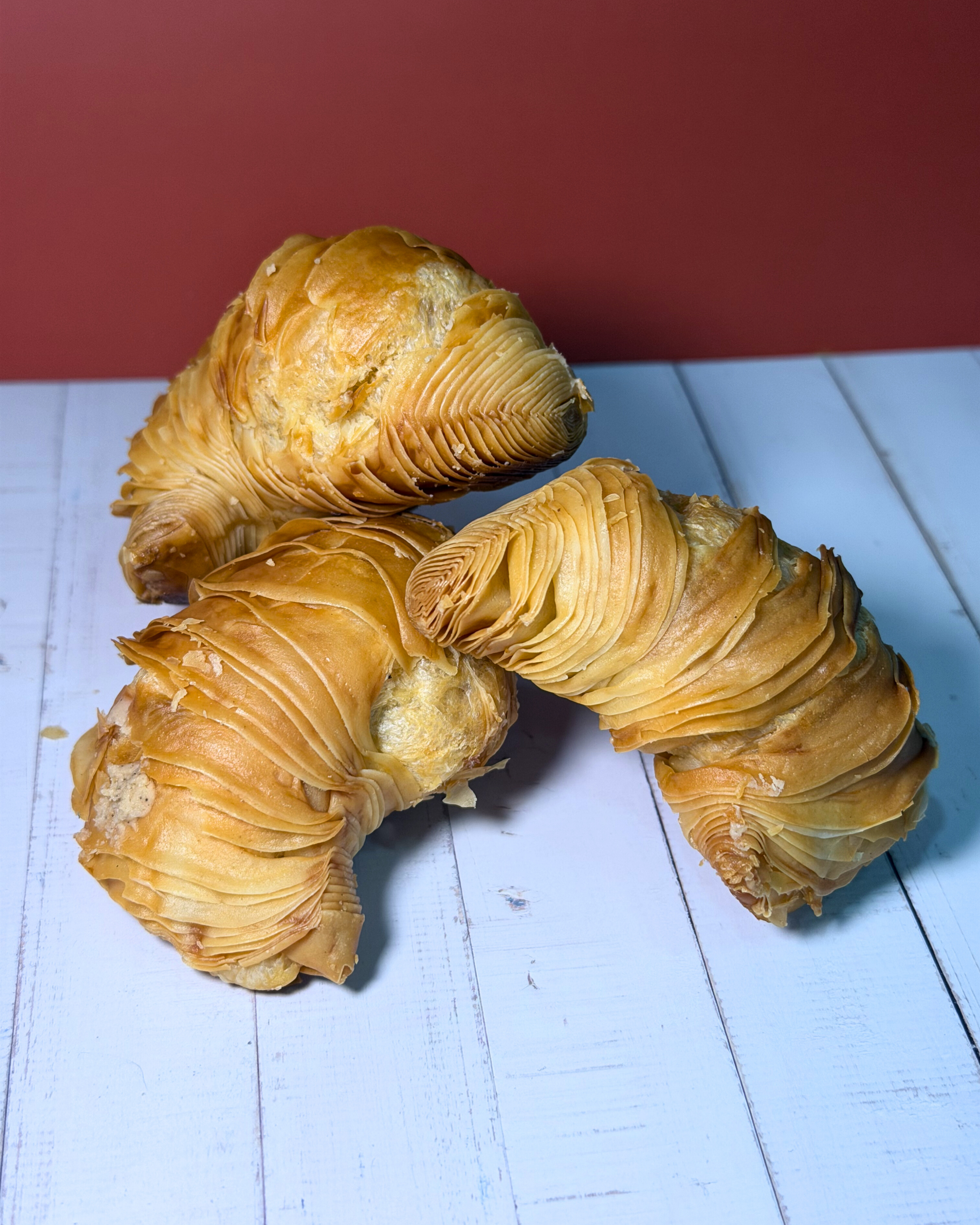 Medri Sfogliatella de Tiramisú, layered Italian pastry filled with creamy tiramisú, golden-brown and flaky crust.