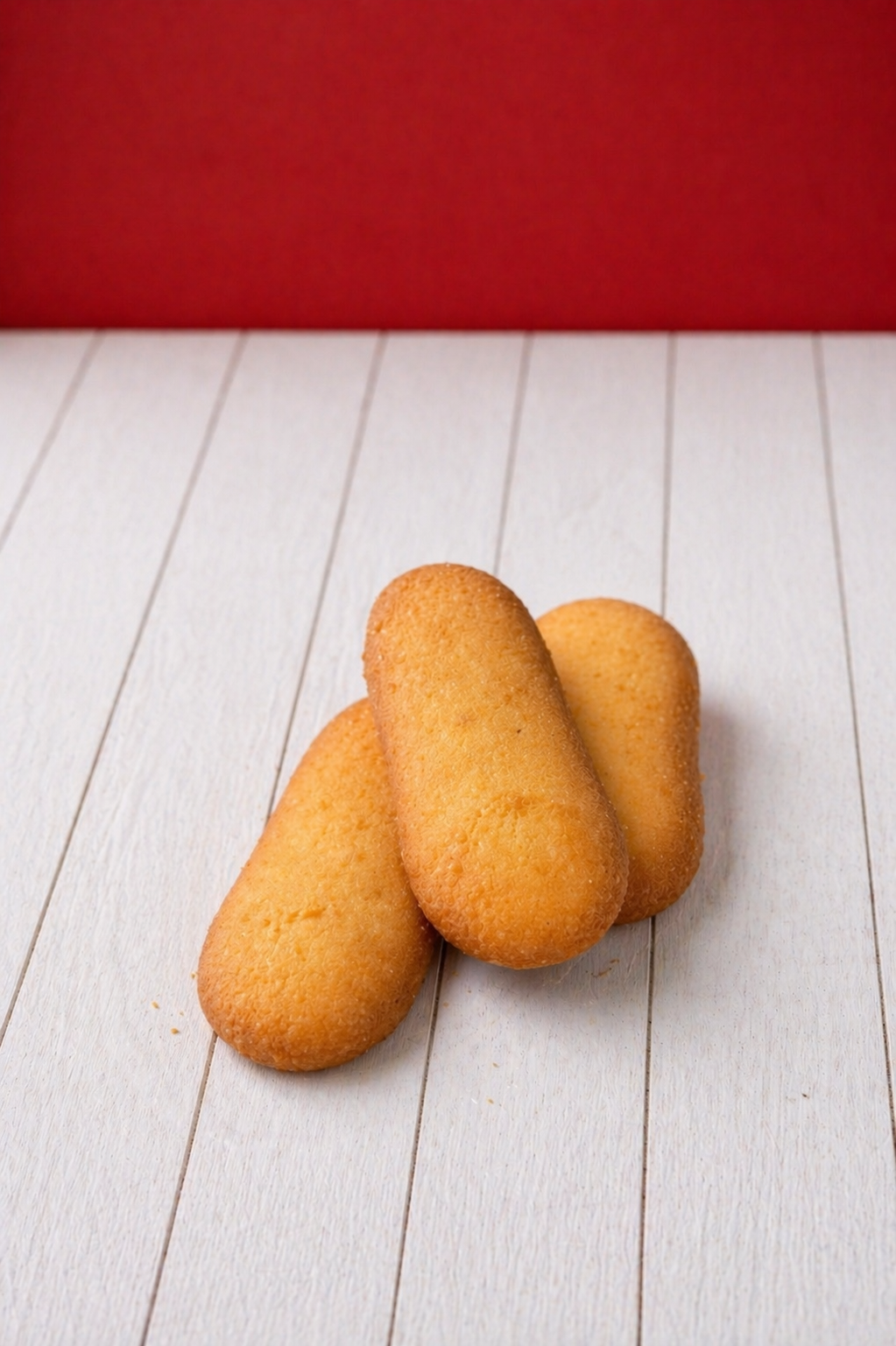 Medri vanilla lengua de gato cookies on a plate, golden-brown biscuits with a delicate, crispy texture and vanilla flavor.