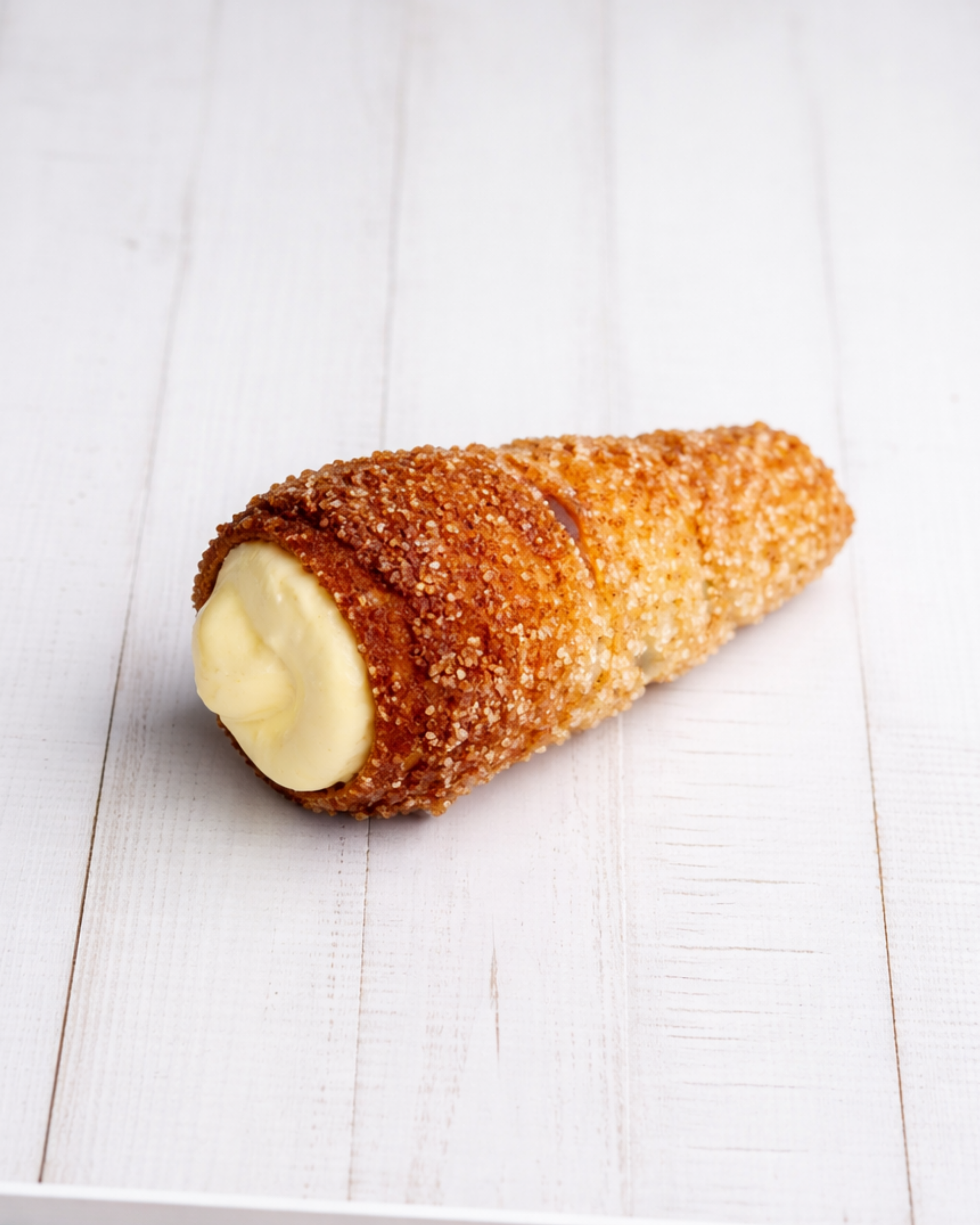 Medri Cannolino Sfoglia Limón pastry with lemon-flavored filling and flaky pastry layers, displayed on a white plate.