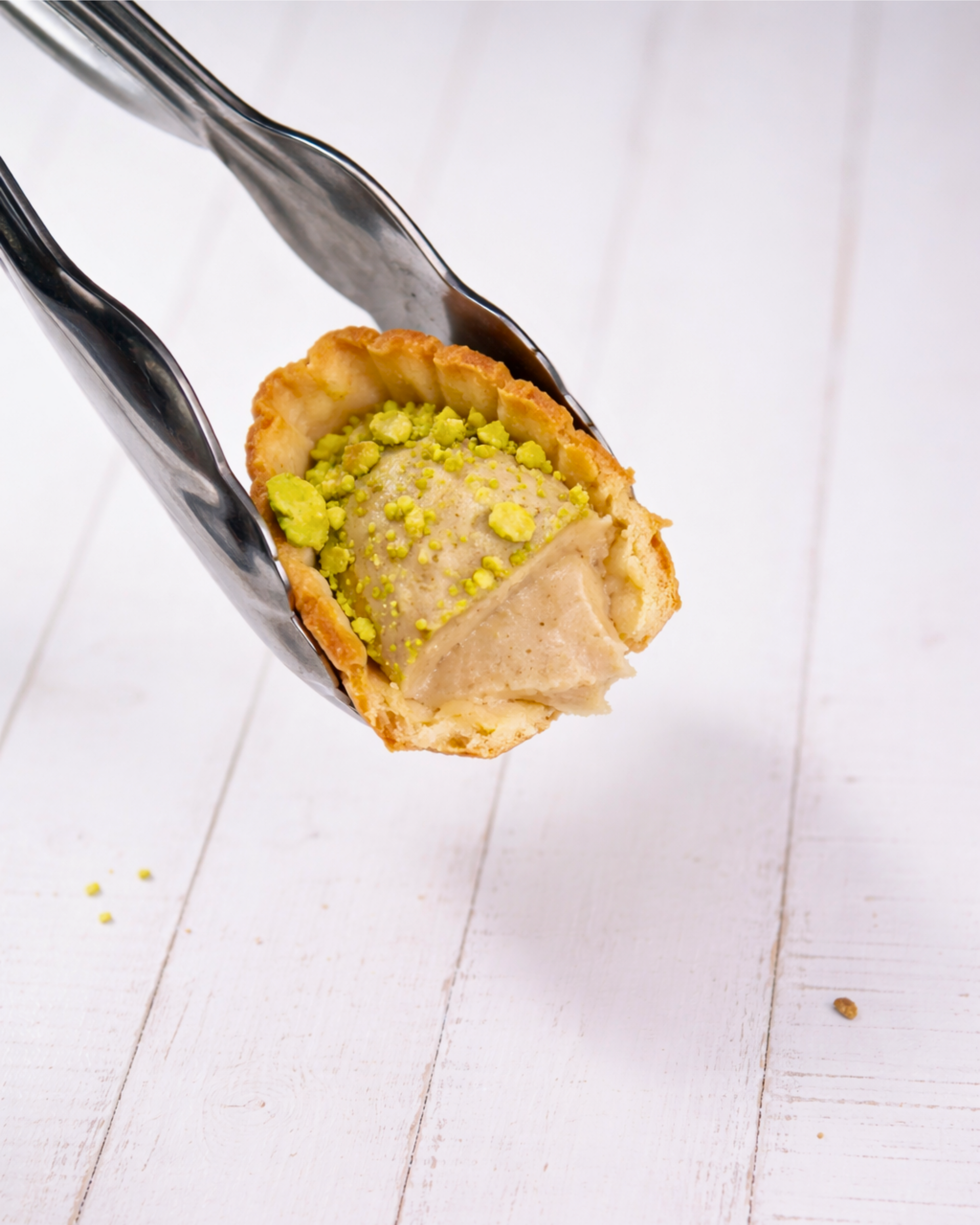 Medri Barchetta Pistacho chocolate bar with pistachio pieces and creamy filling, displayed on a white plate.