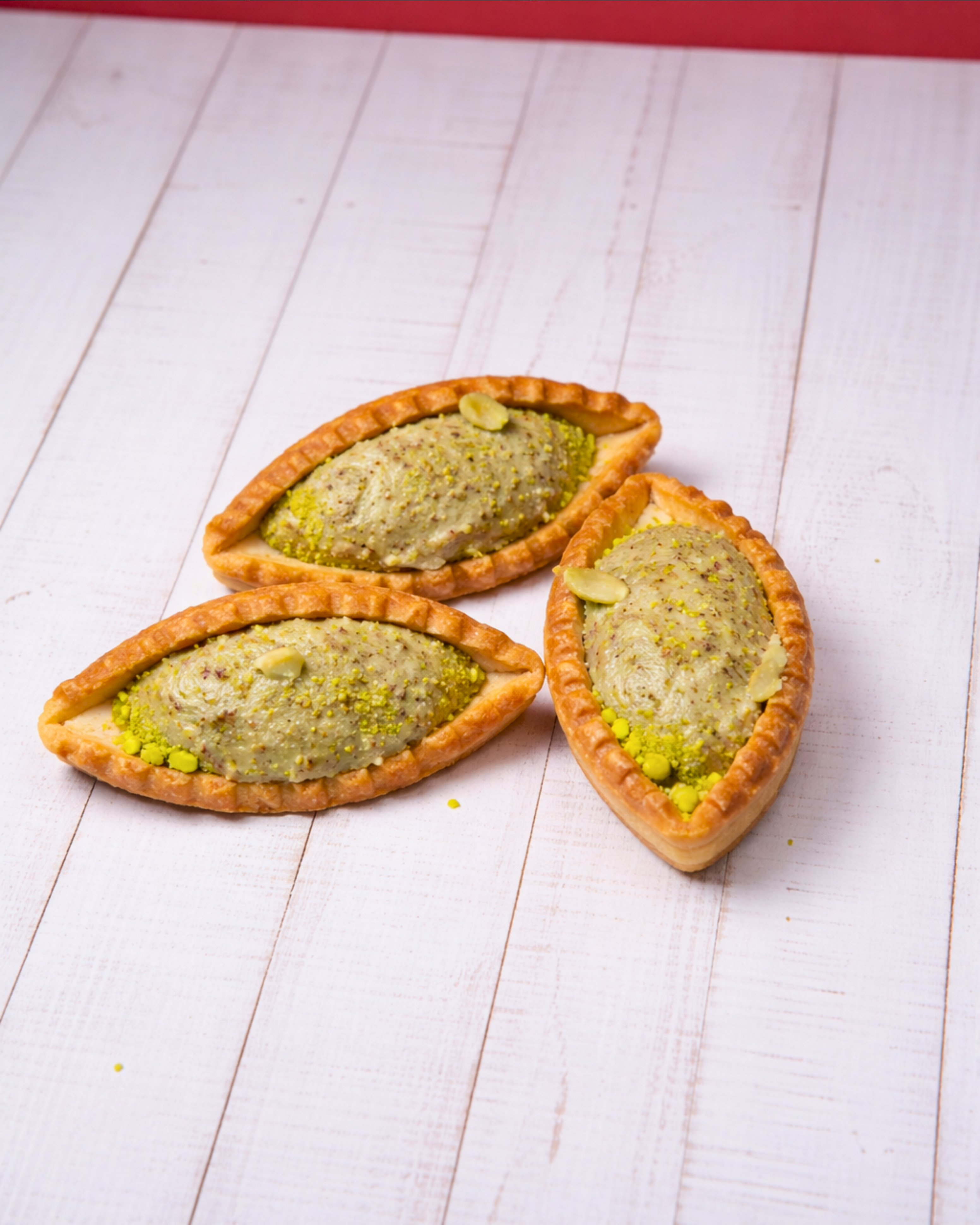 Medri Barchetta Pistacho, a pastel green pistachio-flavored confection with a boat-shaped design, displayed on a white plate.