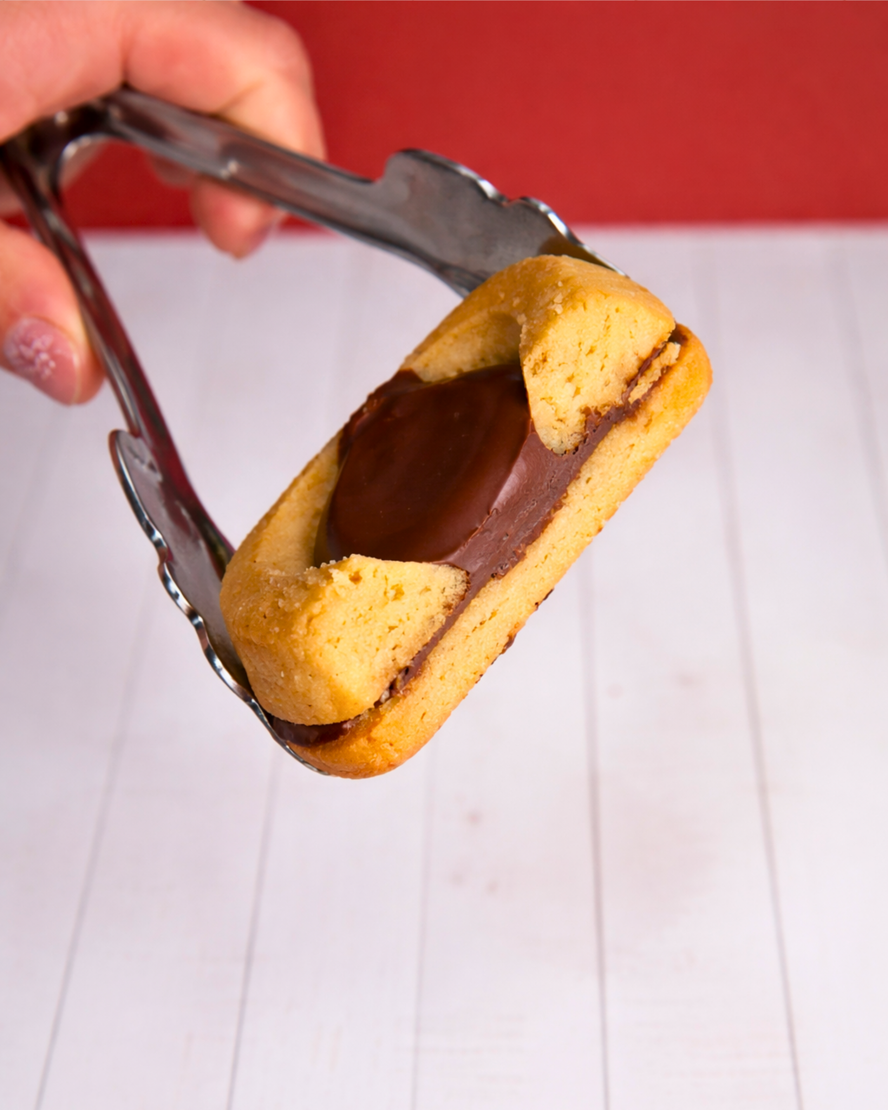 Medri Occhi di Bue Nocciola cookies with hazelnut filling on a white plate, showcasing their golden-brown exterior.